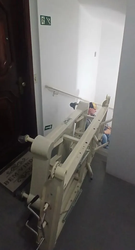 Cama hospitalar sendo conduzida por uma escada estreita