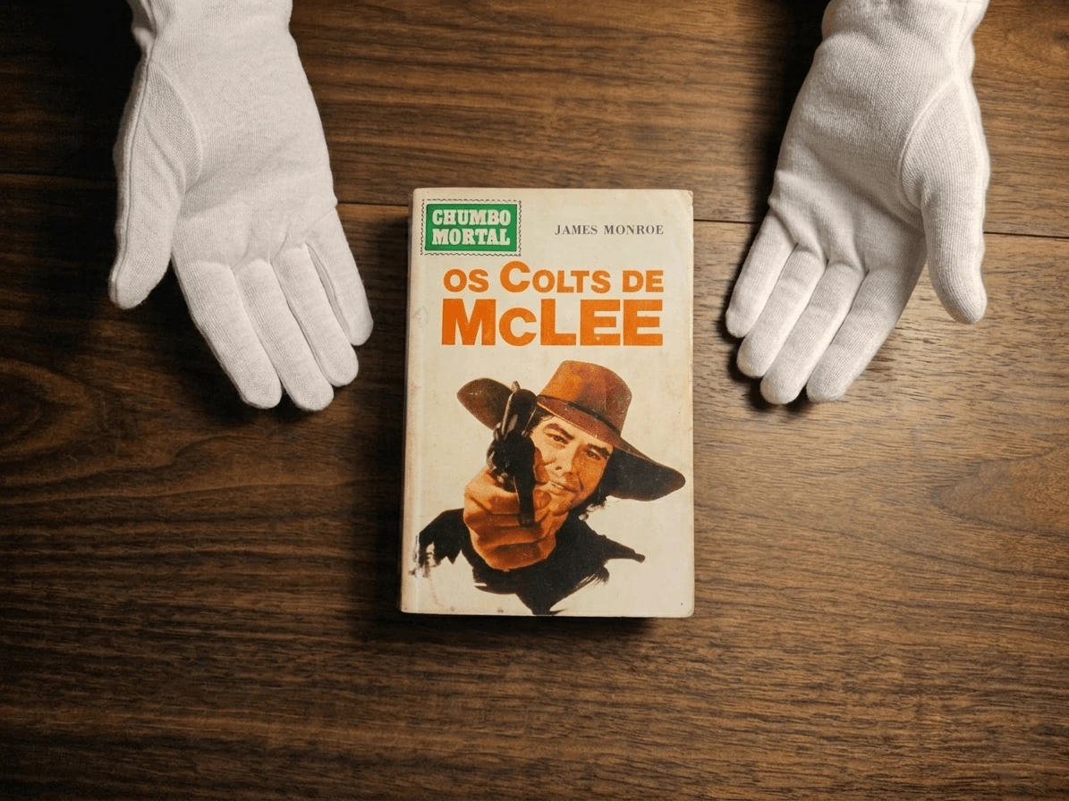 Primeira edição de Os Colts de McLee com a capa frontal apoiada sobre mesa de madeira e mãos com luvas brancas ao redor.